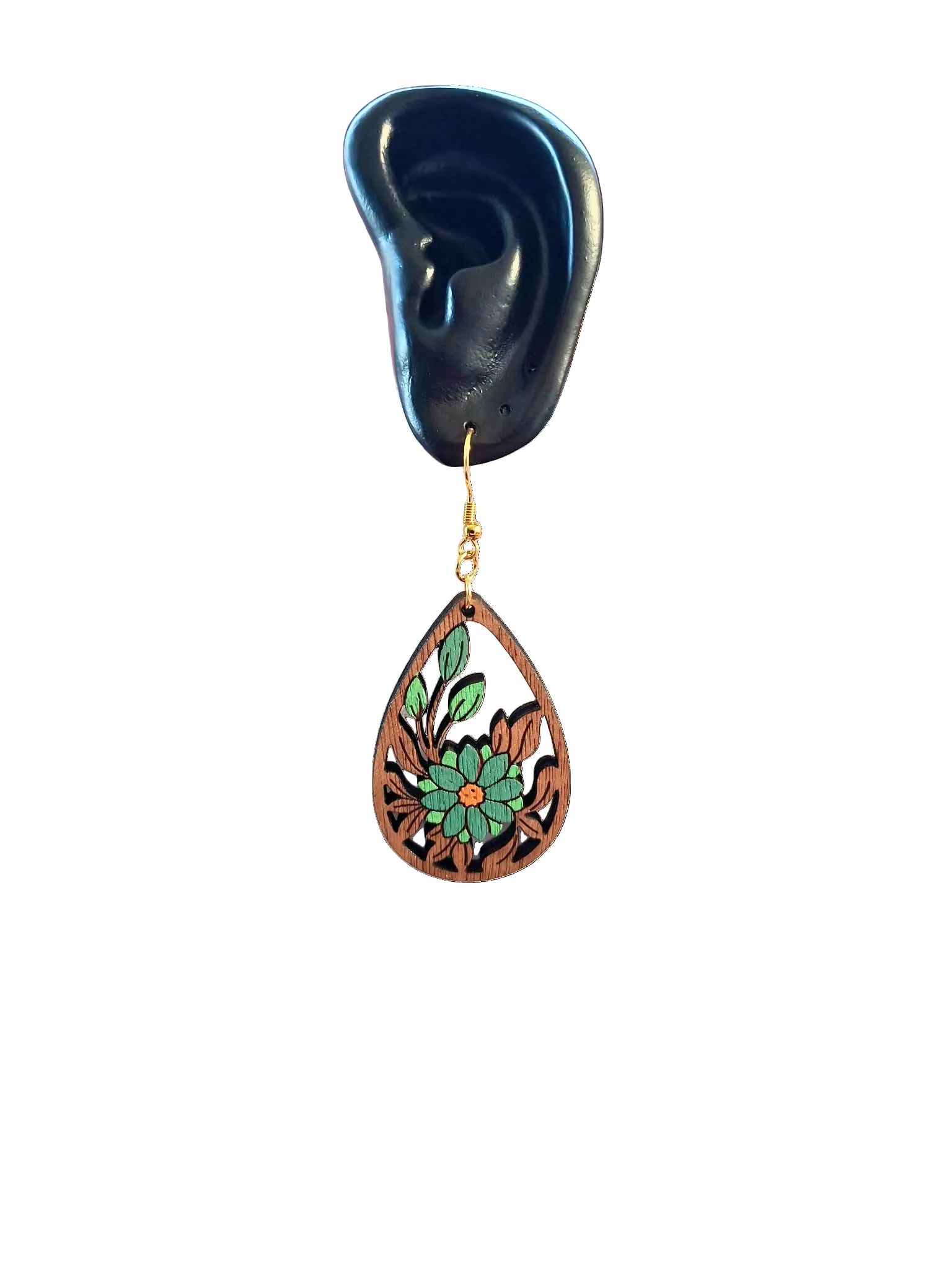 Teardrop-shaped earring with floral design on an ear model against a white background