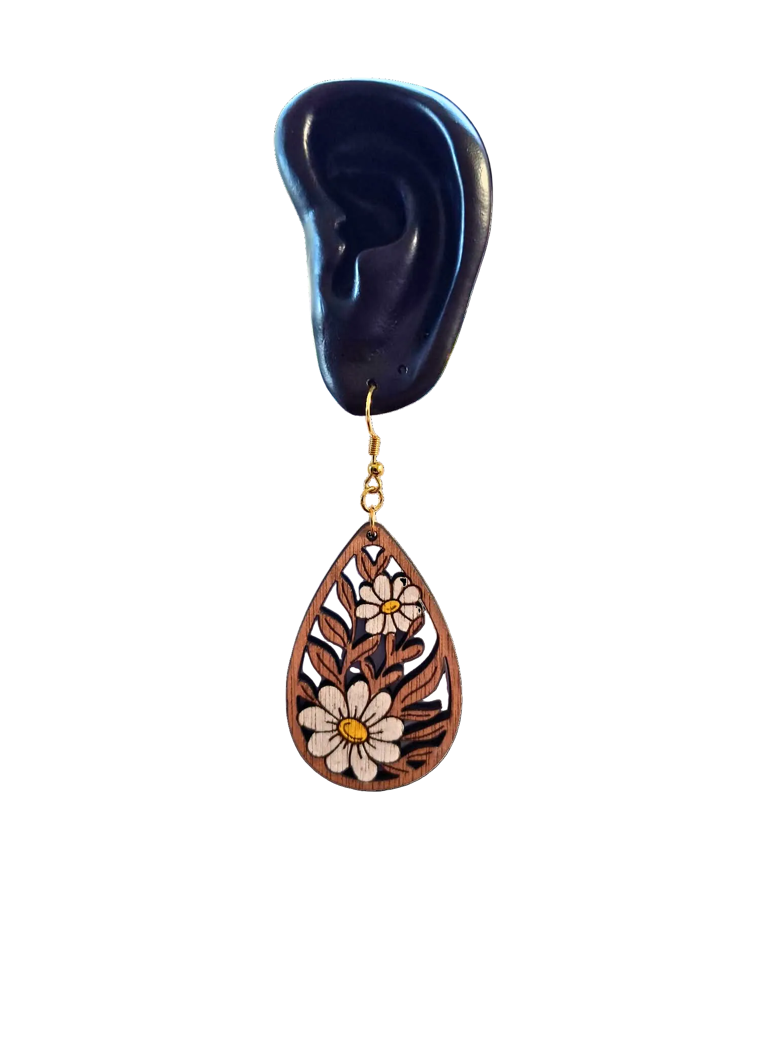 Wooden floral teardrop earring on a black ear model with a white background