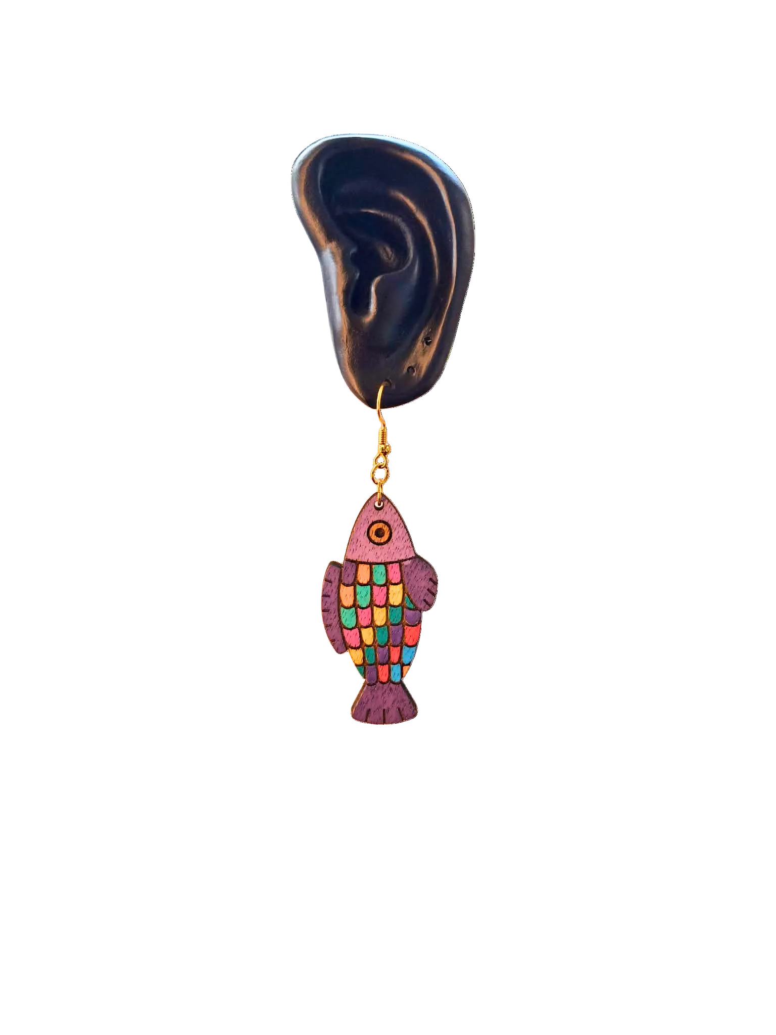 Colorful fish-shaped earring hanging from a model ear on a white background