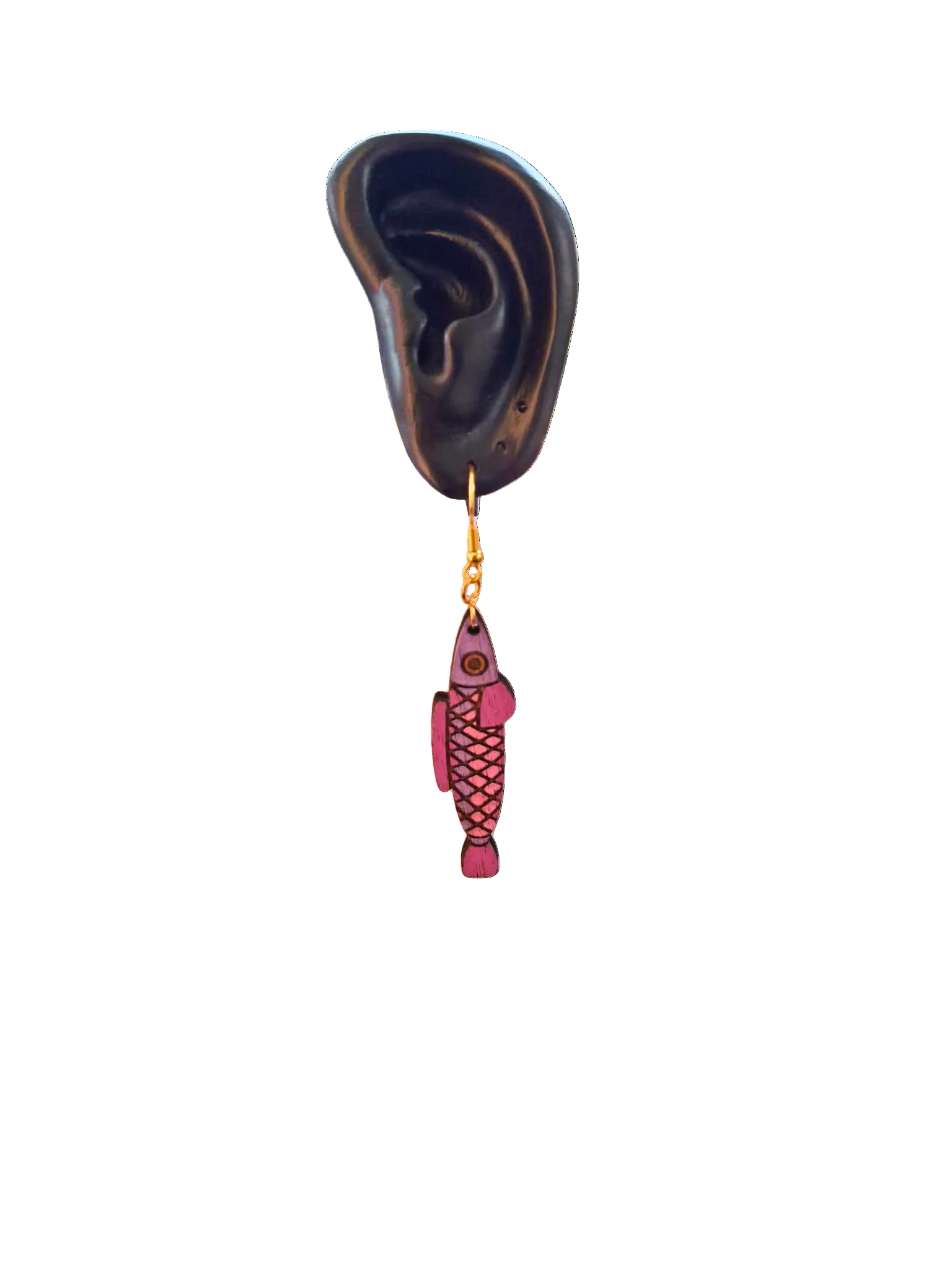 Fishing lure shaped like a fish hanging from an ear with an ear model on a white background