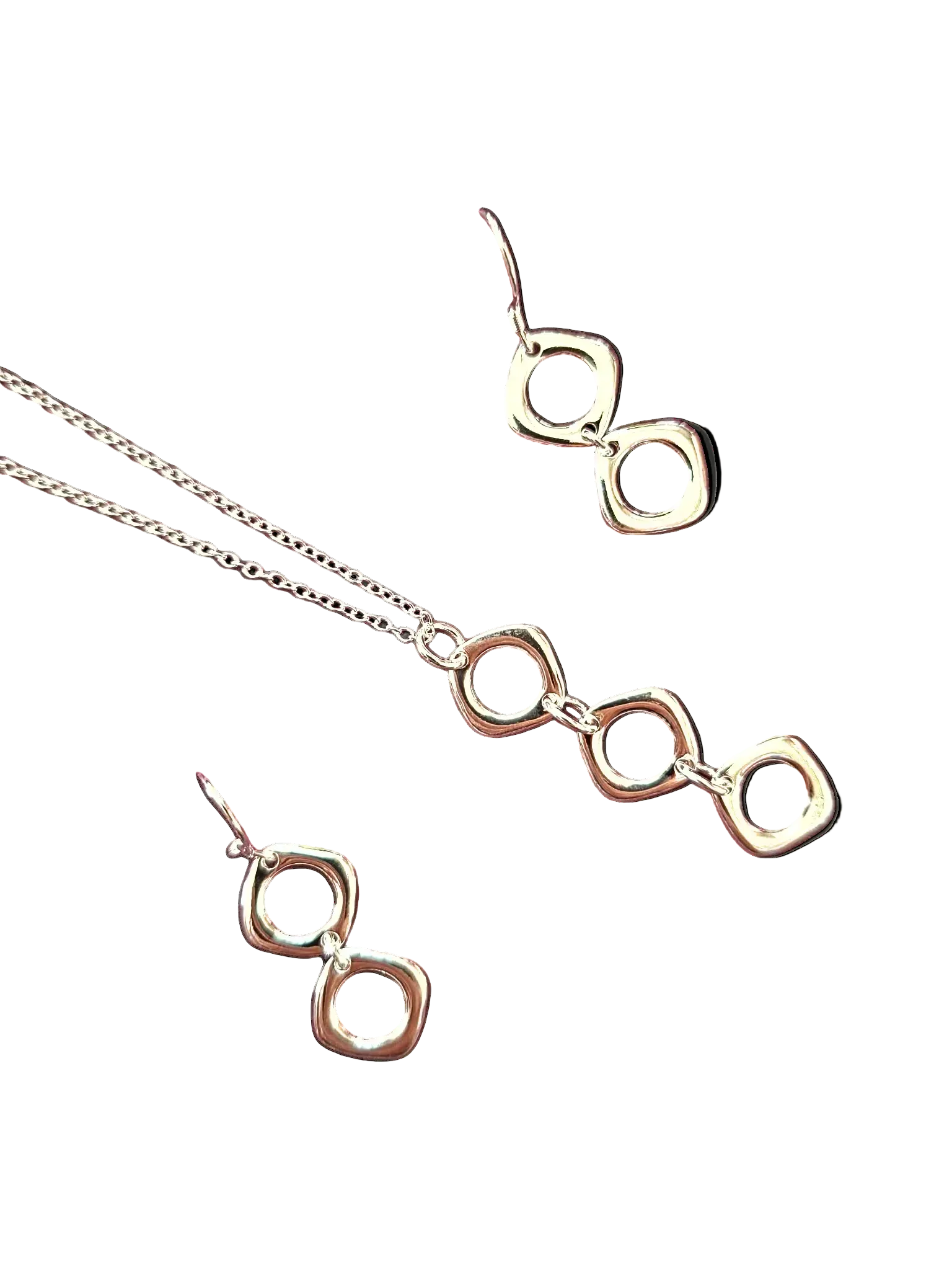 Silver necklace and earrings set on a white background